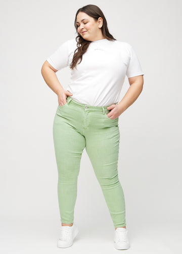Skinny-jeans til kvinner i lysegrønn, fargen Mints. Helhetsbilde av en plus size-modell med jeansene på.