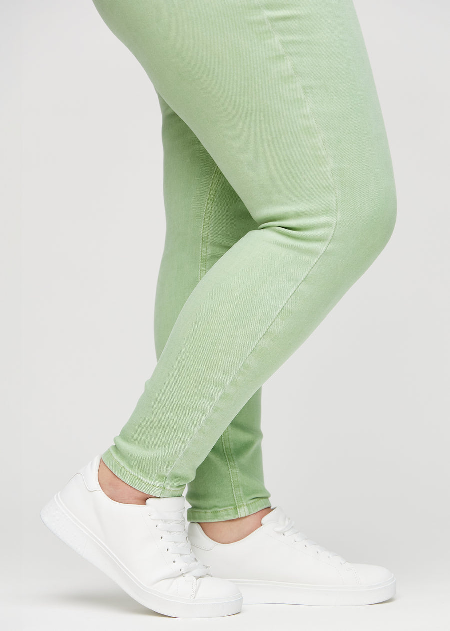 Skinny-jeans til kvinner i lysegrønn, fargen Mints. Nærbilde ved anklene på en plus size-modell, som viser de tettsittende benåpningene.