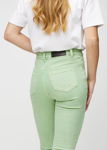 Skinny-jeans til kvinner i lysegrønn, fargen Mints. Nærbilde bakfra på en modell for å vise detaljer.