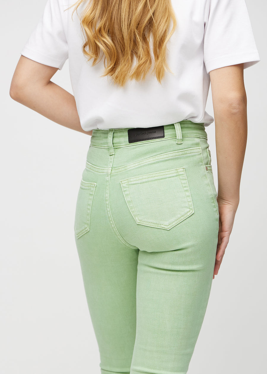 Skinny-jeans til kvinner i lysegrønn, fargen Mints. Nærbilde bakfra på en modell for å vise detaljer.