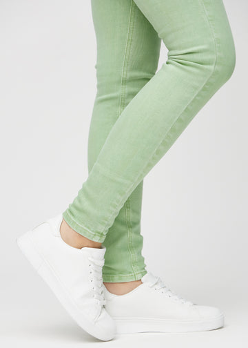 Skinny-jeans til kvinner i lysegrønn, fargen Mints. Nærbilde ved anklene på en modell, som viser de tettsittende benåpningene.