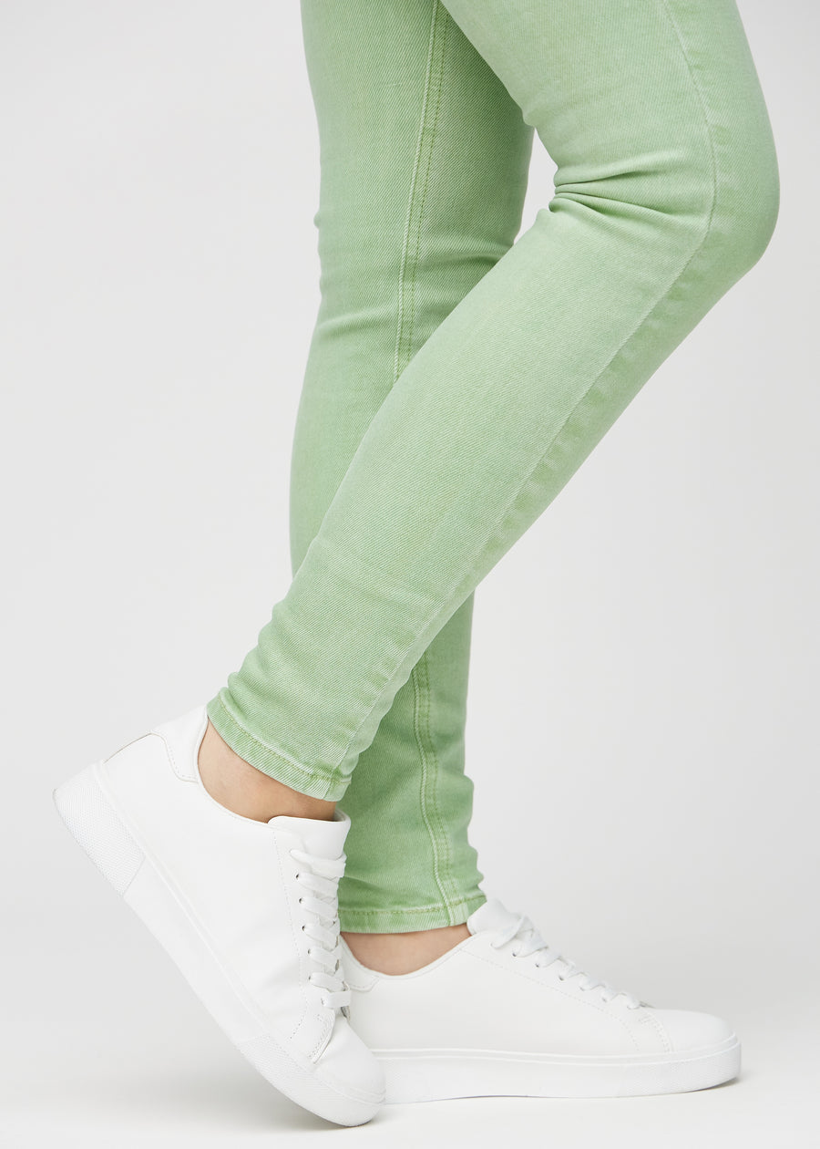 Skinny-jeans til kvinner i lysegrønn, fargen Mints. Nærbilde ved anklene på en modell, som viser de tettsittende benåpningene.