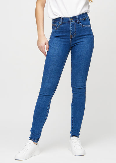 Skinny-jeans til kvinner i mørkeblå, fargen Oceans. Sett forfra på en modell, med tettsittende ben.