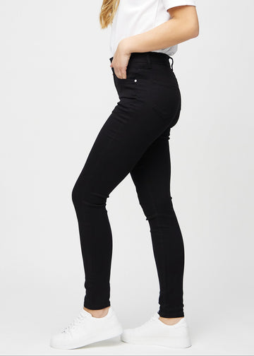 Svarte skinny jeans sett fra siden på modell.