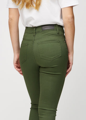 Skinny-jeans til kvinner i mørkegrønn, fargen Renewals. Nærbilde bakfra på en modell for å vise detaljene.