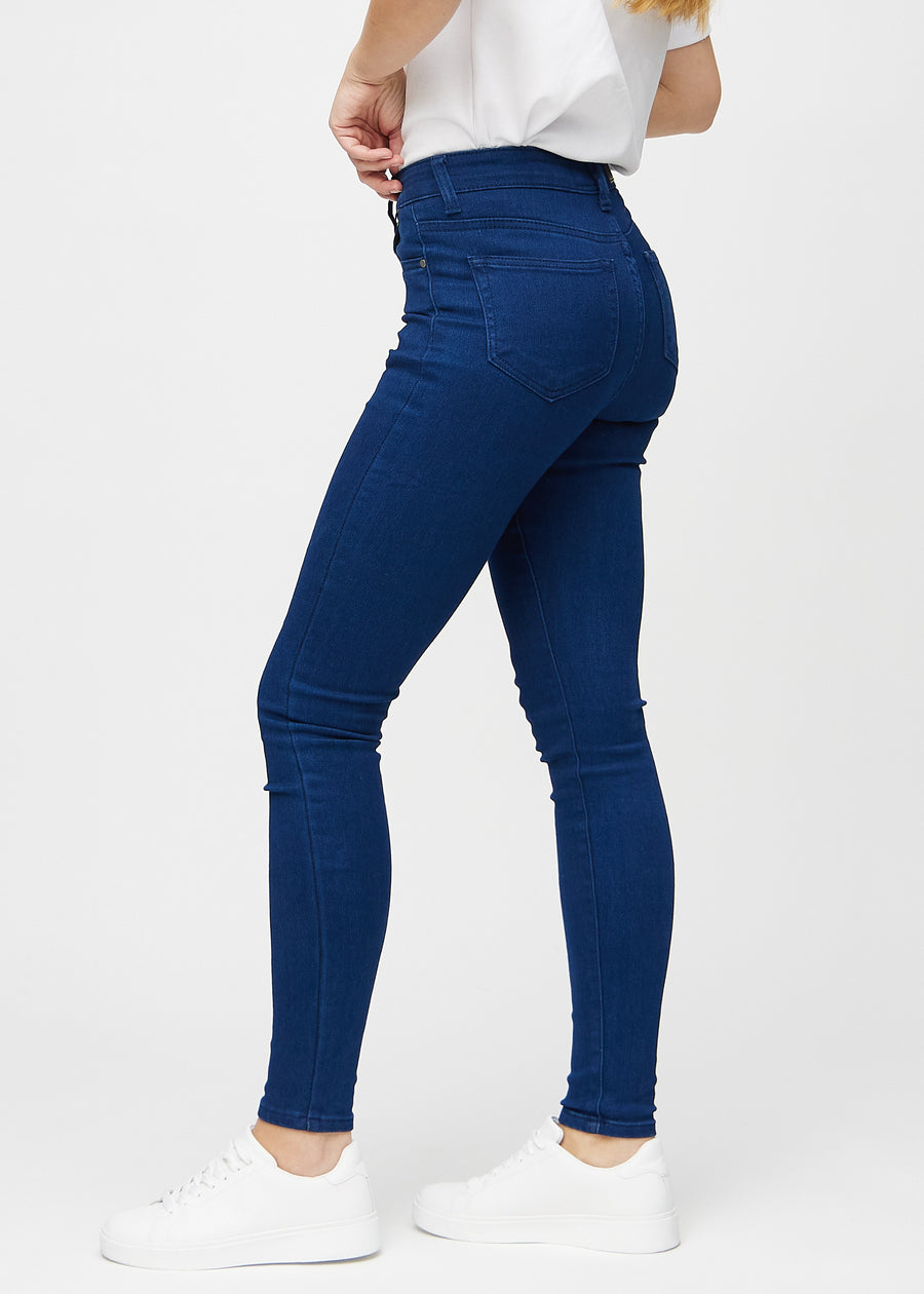 Mørkeblå skinny jeans sett fra siden på modell.