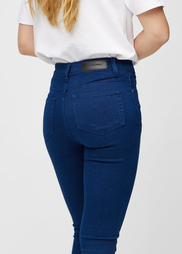 Mørkeblå skinny jeans sett bakfra på nært hold for å vise detaljer.