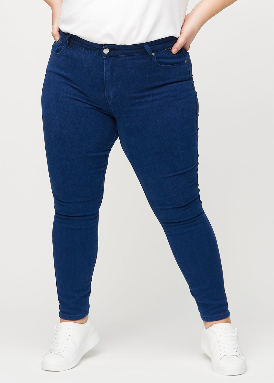 Mørkeblå skinny jeans, modellnavn Royals, som sitter tett til benet på en plus-size-modell, sett forfra.
