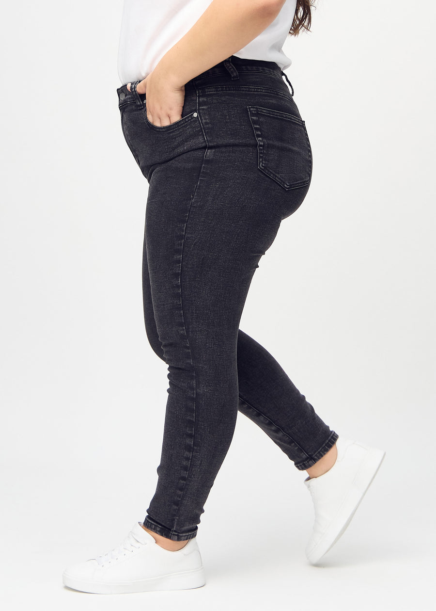 Skinny-jeans til kvinner i mørkegrå, fargen Shadows. Sett fra siden på en plus size-modell.