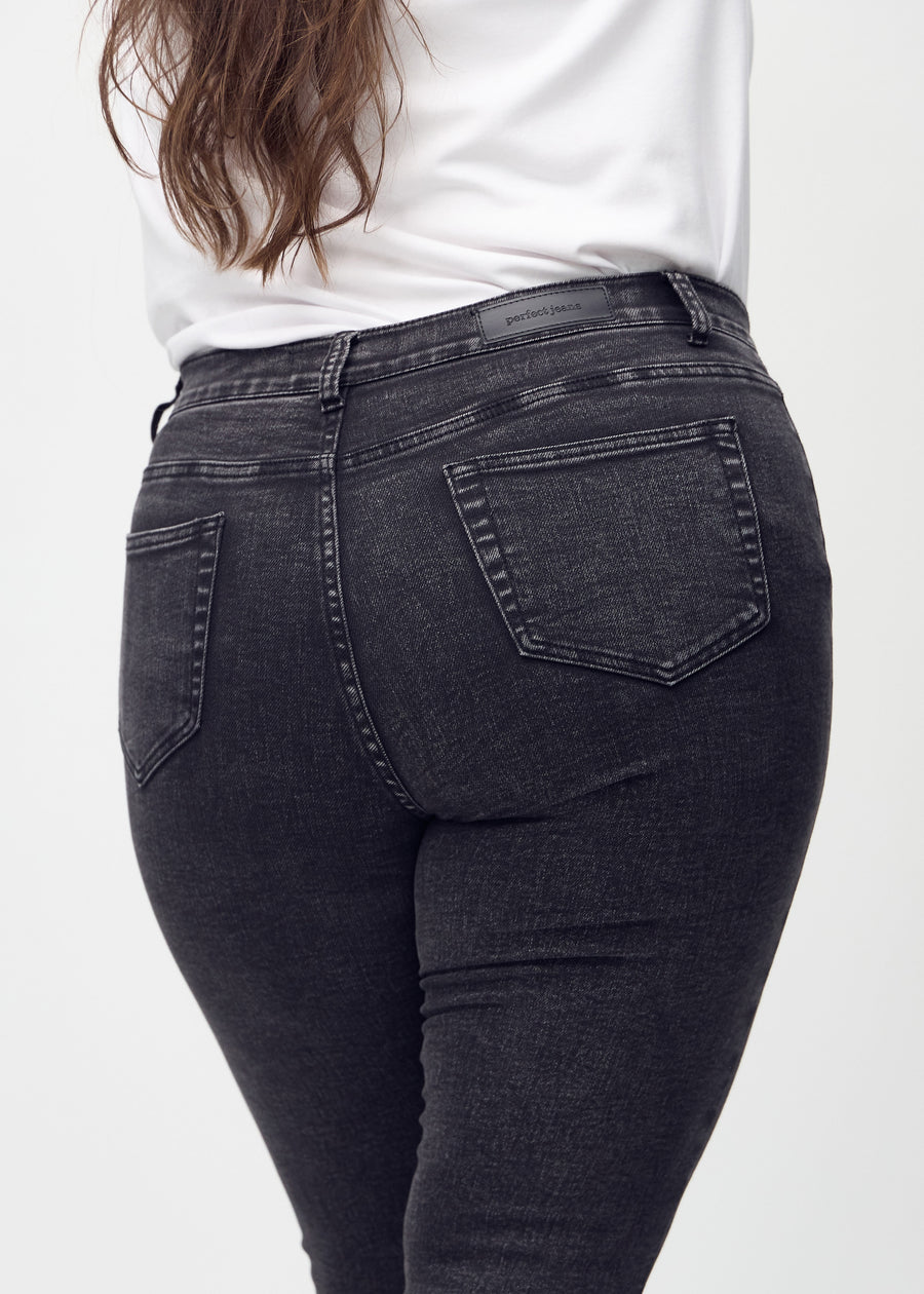Skinny-jeans til kvinner i mørkegrå, fargen Shadows. Nærbilde bakfra på en plus size-modell for å vise detaljer.