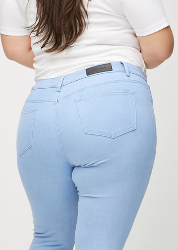 Skinny-jeans til kvinner i lyseblå, fargen Skies. Nærbilde bakfra på en plus size-modell for å vise detaljene.