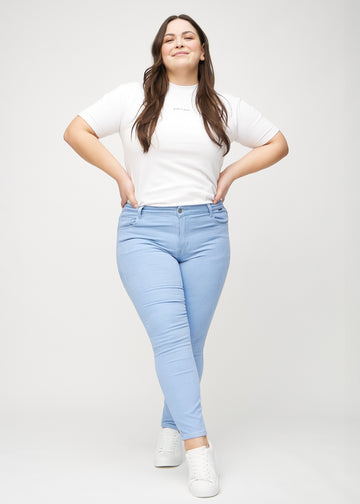 Skinny-jeans til kvinner i lyseblå, fargen Skies. Helhetsbilde av en plus size-modell med jeansene på.