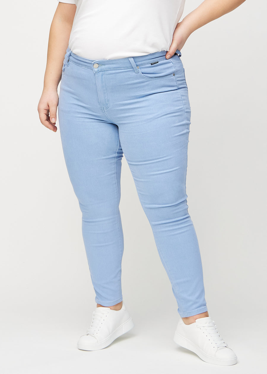 Skinny-jeans til kvinner i lyseblå, fargen Skies. Sett forfra på en plus size-modell, med tett passform rundt bena.