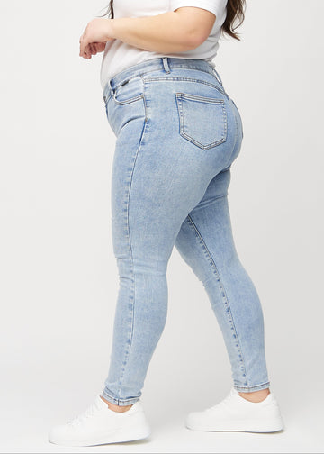 Skinny-jeans til kvinner i lyseblå, fargen Waves. Sett fra siden på en plus size-modell.