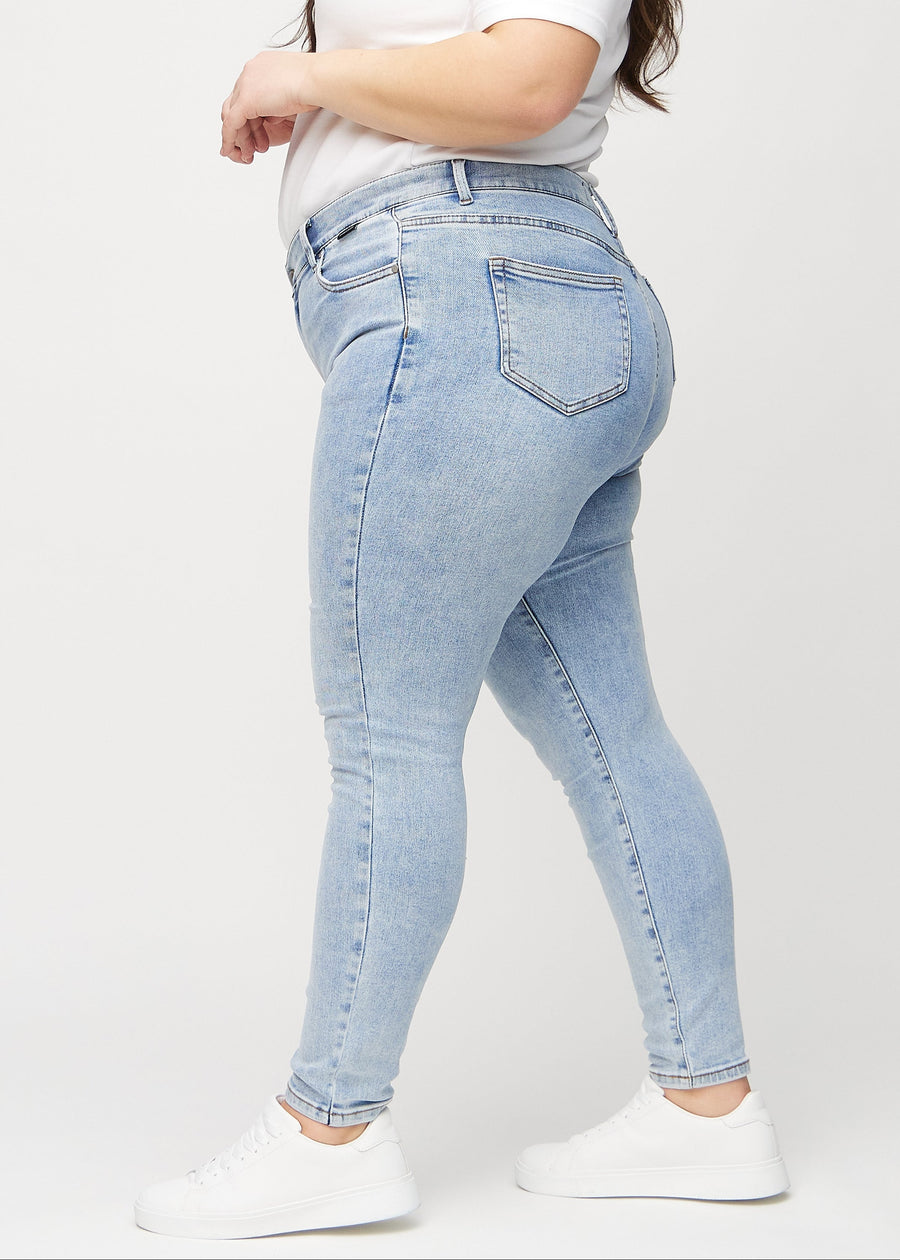 Skinny-jeans til kvinner i lyseblå, fargen Waves. Sett fra siden på en plus size-modell.