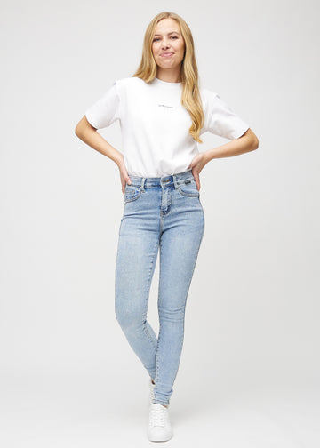 Skinny-jeans til kvinner i lyseblå, fargen Waves. Helhetsbilde av en modell med jeansene på.