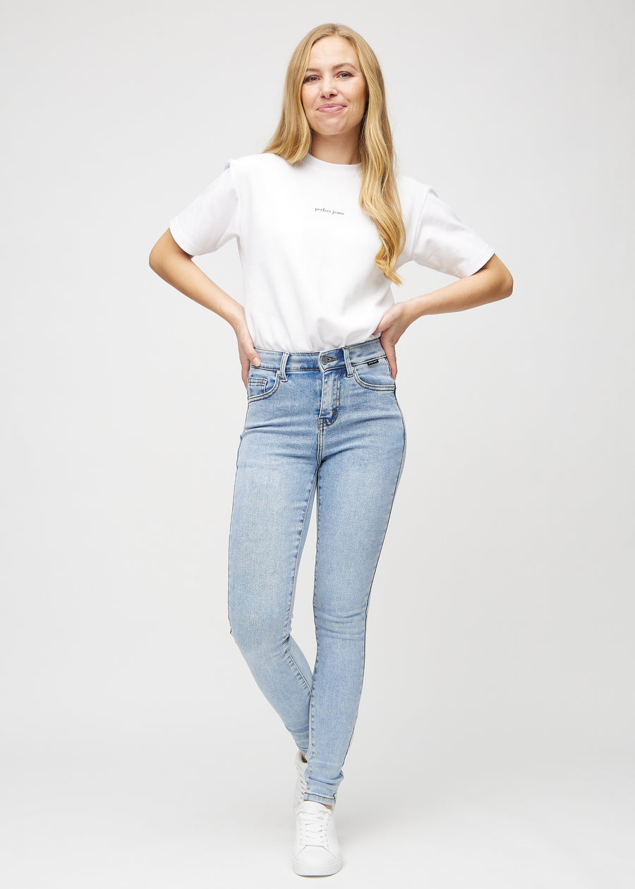 Skinny-jeans til kvinner i lyseblå, fargen Waves. Helhetsbilde av en modell med jeansene på.