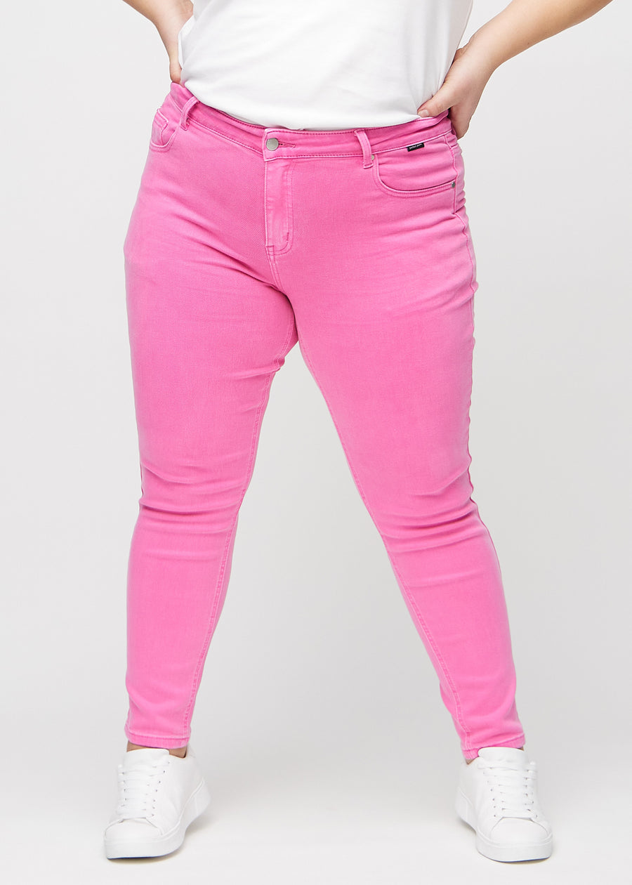 Slim-jeans til kvinner i lyserosa, fargen Flamingos. Sett forfra på en plus size-modell, med tettsittende ben og litt mer plass ved anklene.