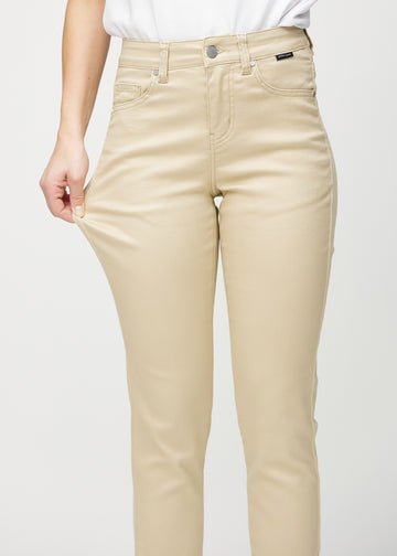 Slim-jeans til kvinner i beige, fargen Gazelles. En modell strekker jeansstoffet ved låret for å vise stretchen.