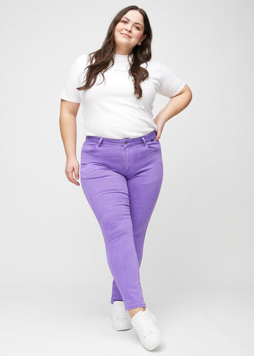 Slim-jeans til kvinner i lilla, fargen Lavenders. Helhetsbilde av en plus size-modell med jeansen på.