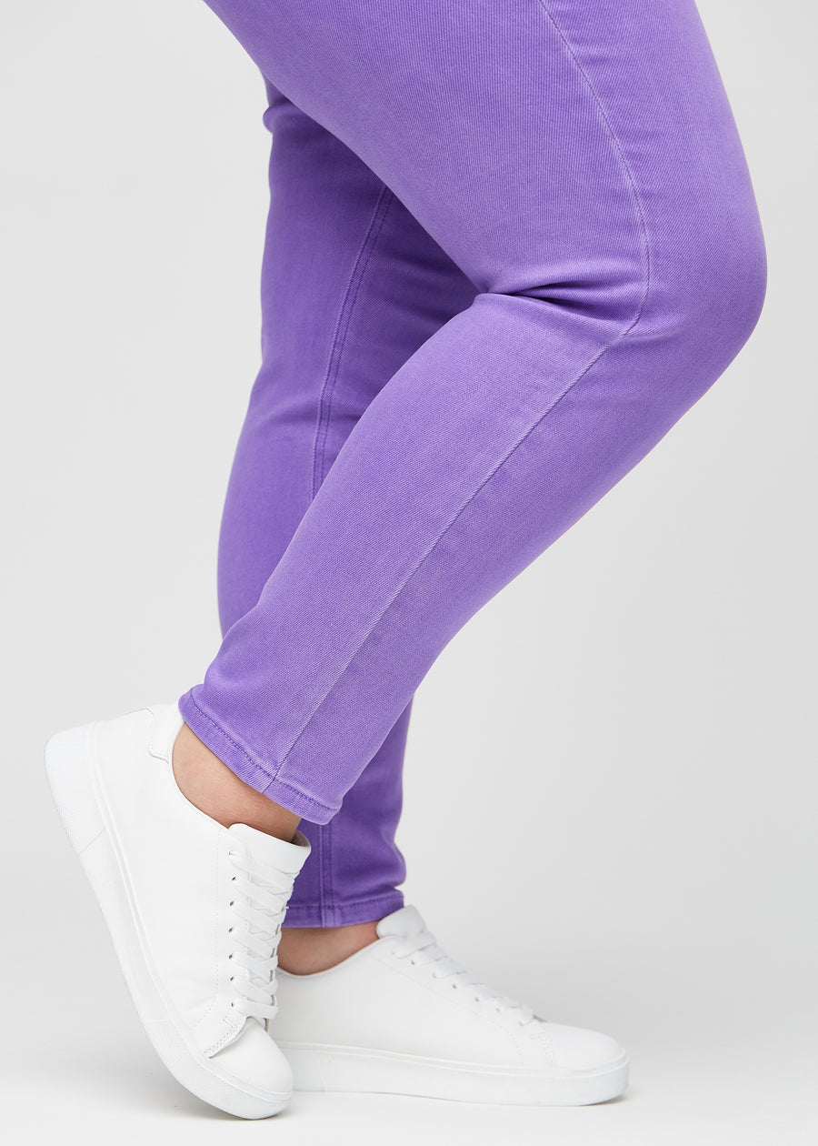 Slim-jeans til kvinner i lilla, fargen Lavenders. Nærbilde ved anklene på en plus size-modell, som viser passformen nederst på bena.
