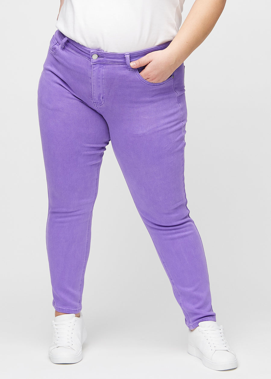 Slim-jeans til kvinner i lilla, fargen Lavenders. Sett forfra på en plus size-modell, med tettsittende ben og litt mer plass ved anklene.
