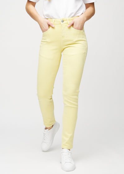 Lysgule slim jeans, modellnavn Lemonades, som sitter tett på benet, men litt løsere ved ankelen, sett forfra.
