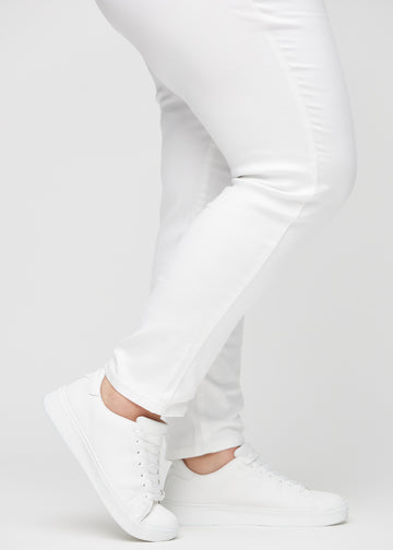 Slim-jeans til kvinner i hvit, fargen Marguerites. Nærbilde ved anklene på en plus size-modell, som viser passformen nederst på bena.