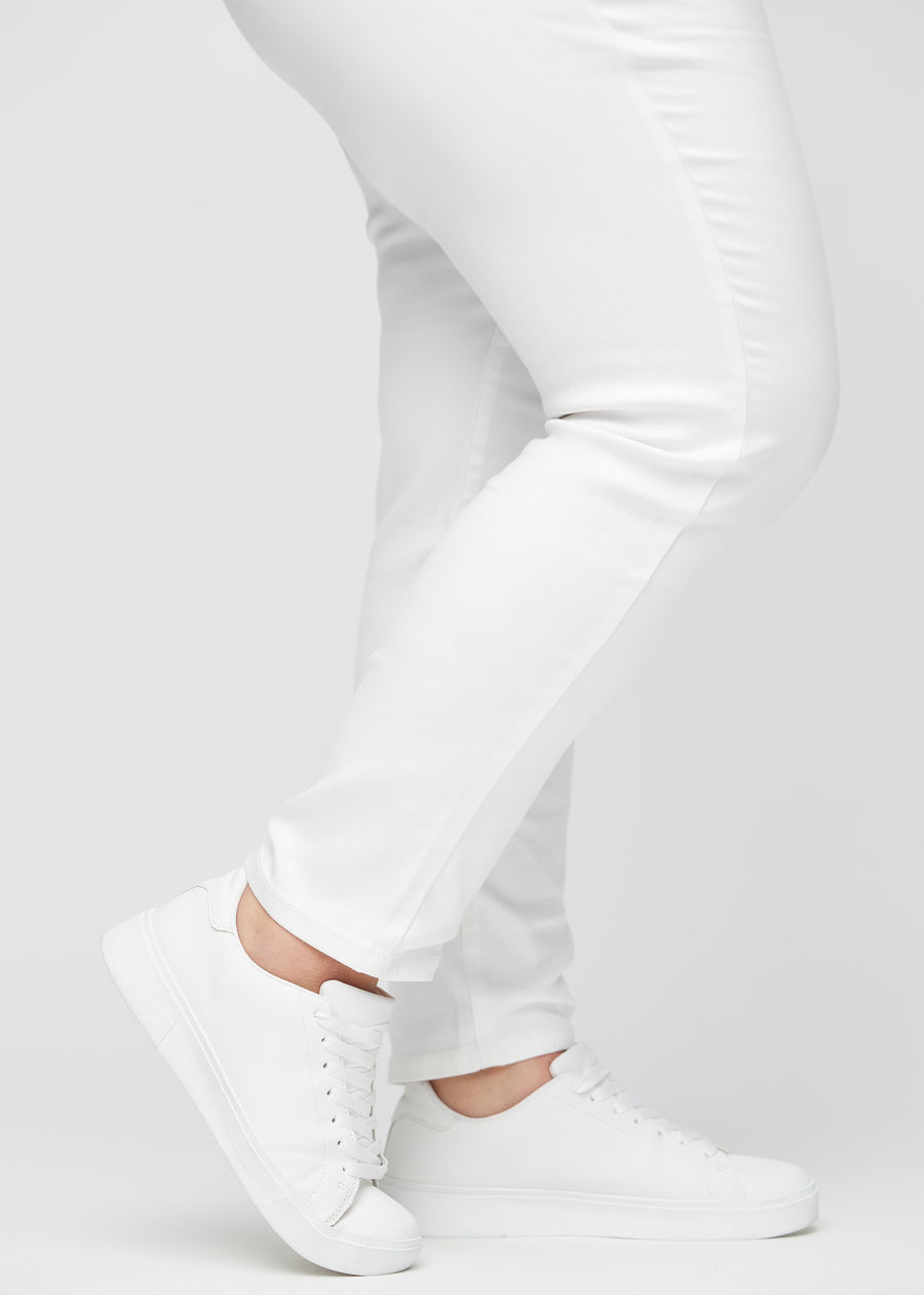 Slim-jeans til kvinner i hvit, fargen Marguerites. Nærbilde ved anklene på en plus size-modell, som viser passformen nederst på bena.