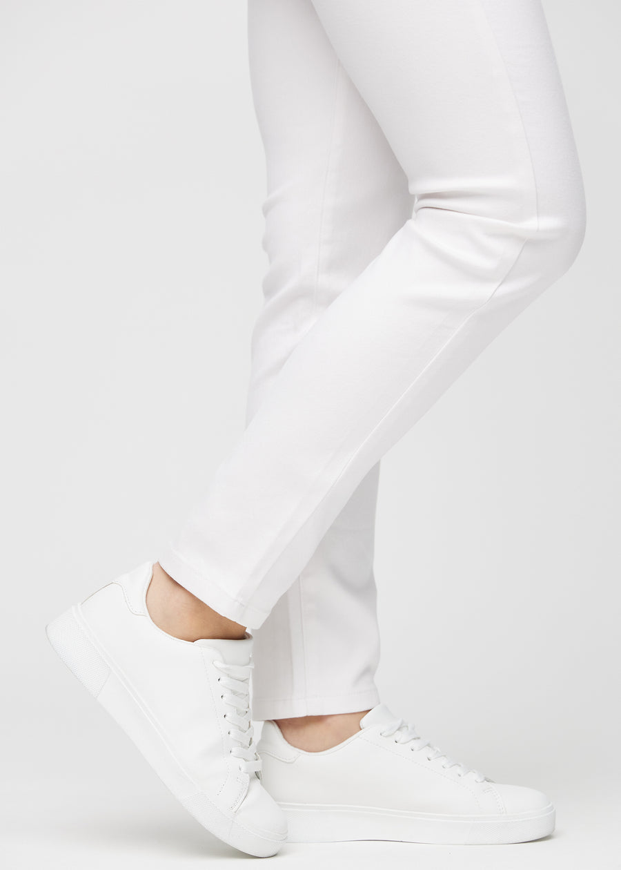 Slim-jeans til kvinner i hvit, fargen Marguerites. Nærbilde ved anklene på en modell, som viser passformen nederst på bena.