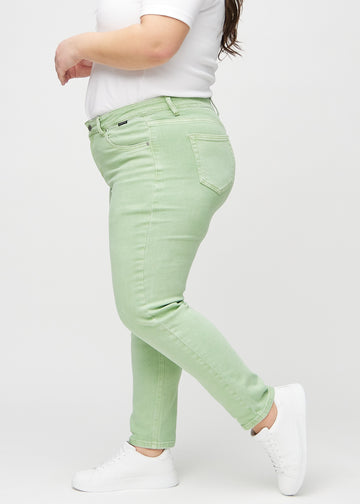 Lysegrønne slim jeans sett fra siden på en plus-size modell.