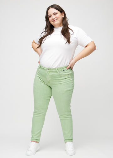 Fullt bilde av en plus-size modell i lysegrønne slim jeans.
