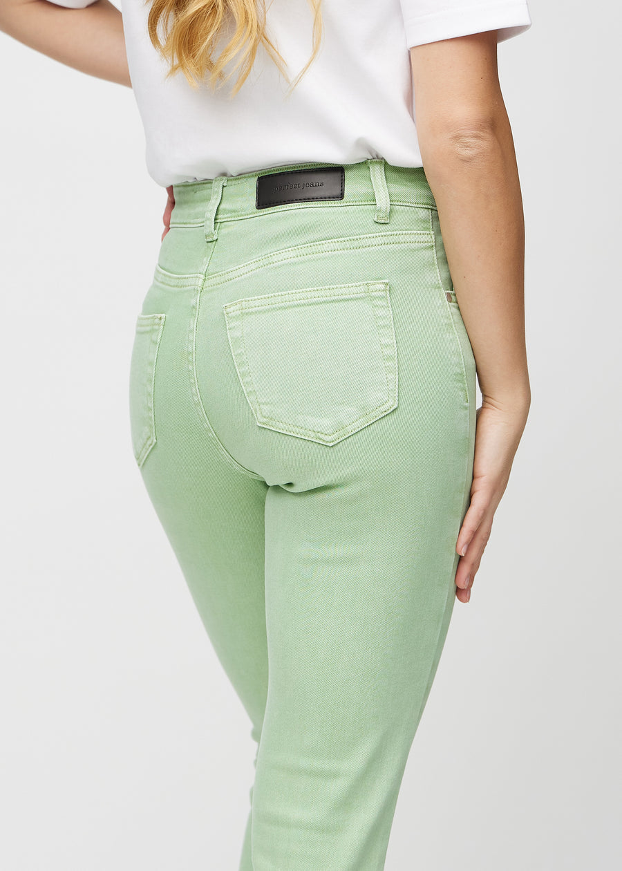 Lysegrønne slim jeans sett bakfra på nært hold for å vise detaljer.