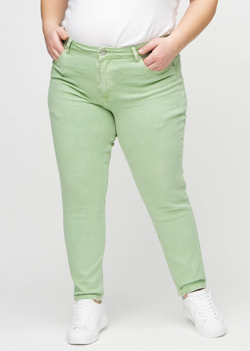 Lysegrønne slim jeans, modellnavn Mints, som sitter tett langs benet, men litt løsere ved ankelen, på en plus-size modell, sett forfra.