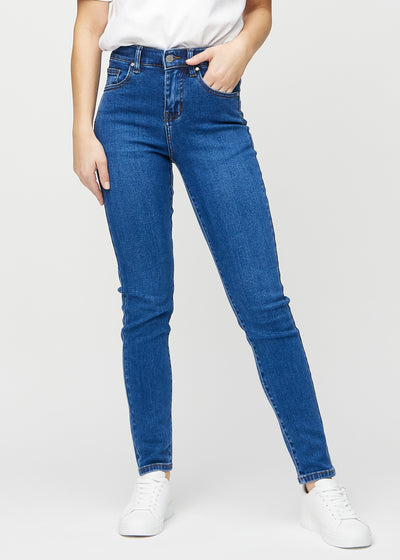 Slim-jeans til kvinner i mørkeblå, fargen Oceans. Sett forfra på en modell, med tettsittende ben og litt mer plass ved anklene.