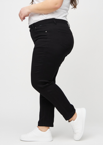 Svarte slim jeans sett fra siden på en plus-size-modell.