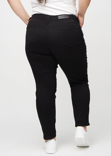 Svarte slim jeans sett bakfra på en plus-size-modell, så man kan se hele produktet.