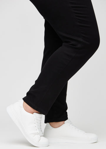 Anklene på en plus-size-modell, så man kan se hvor tett jeansene sitter i en Slim passform.
