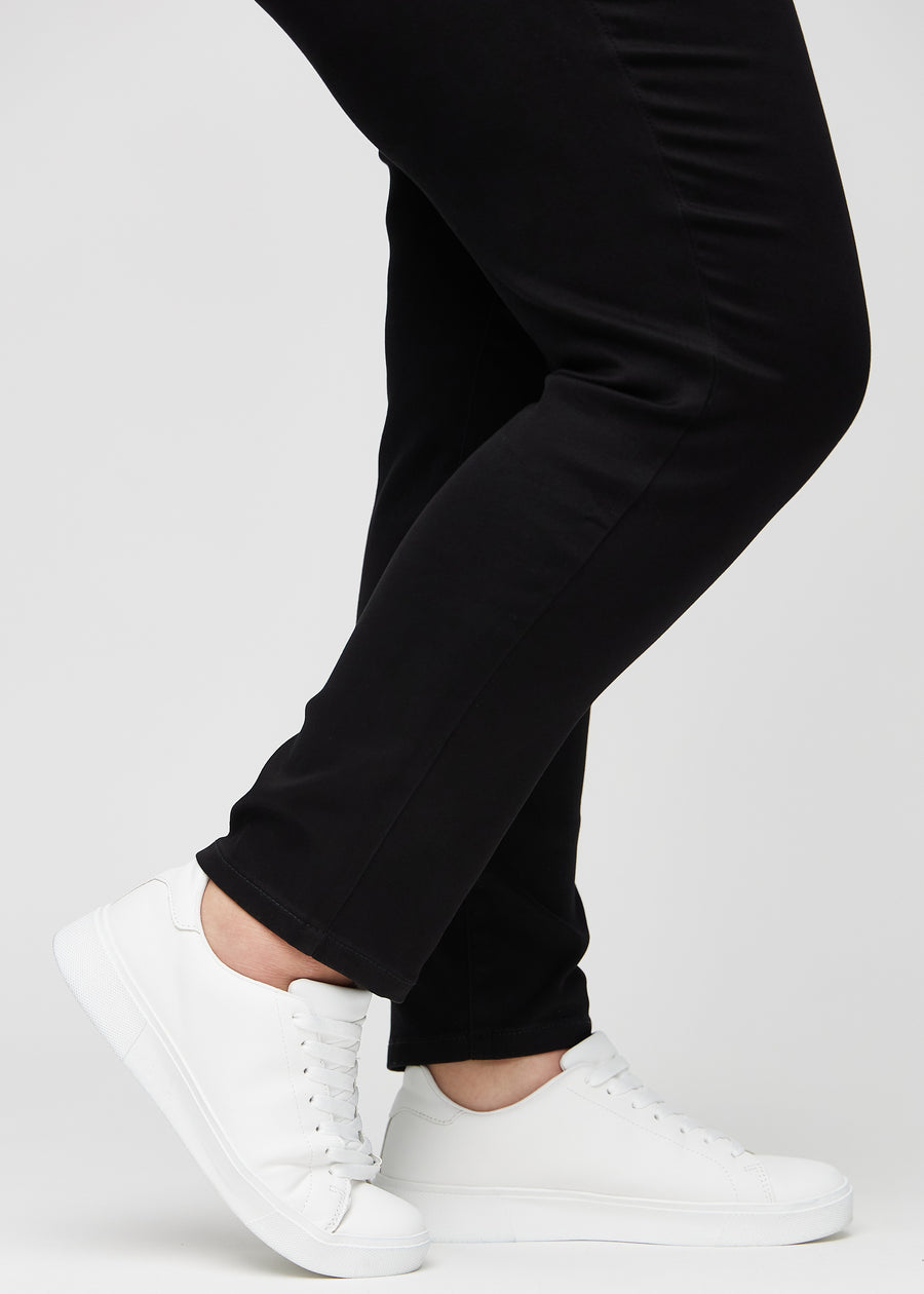 Anklene på en plus-size-modell, så man kan se hvor tett jeansene sitter i en Slim passform.