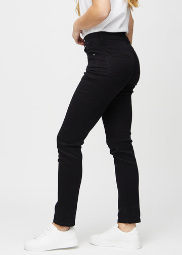 Svarte slim jeans sett fra siden på modell.