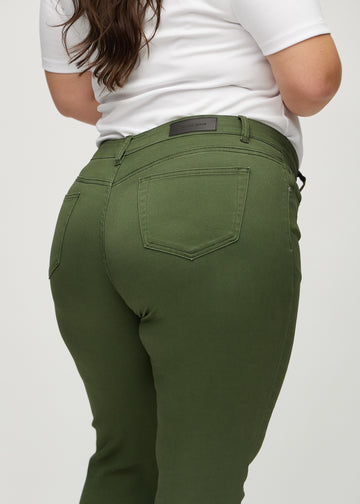 Slim-jeans til kvinner i mørkegrønn, fargen Renewals. Nærbilde bakfra på en plus size-modell for å vise detaljene.