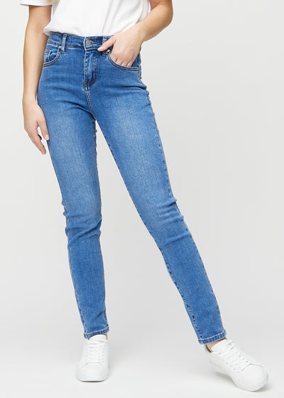 Slim-jeans til kvinner i blå, fargen Rivers. Sett forfra på en modell, med tettsittende ben og litt mer plass ved anklene.