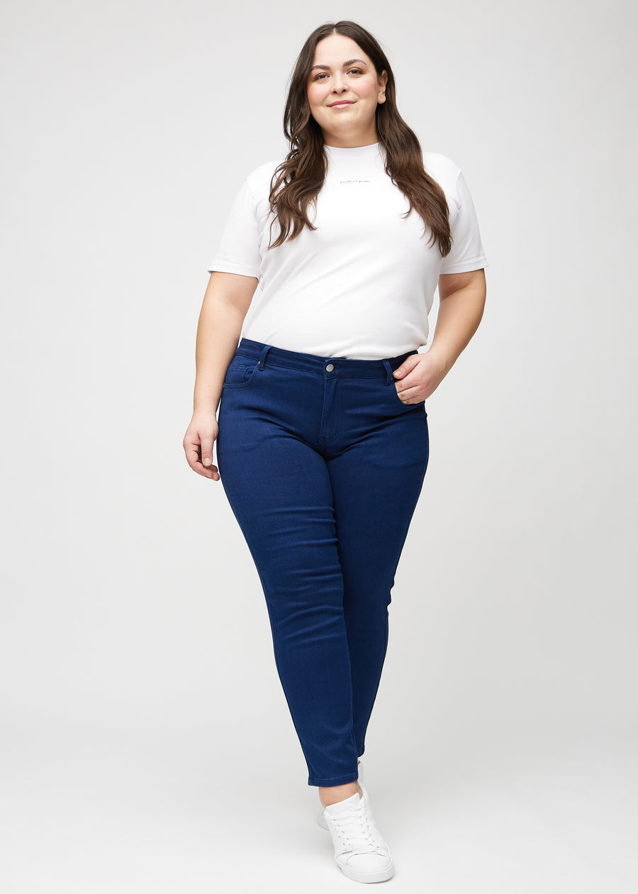 Slim-jeans til kvinner i mørkeblå, fargen Royals. Helhetsbilde av en plus size-modell med jeansen på.