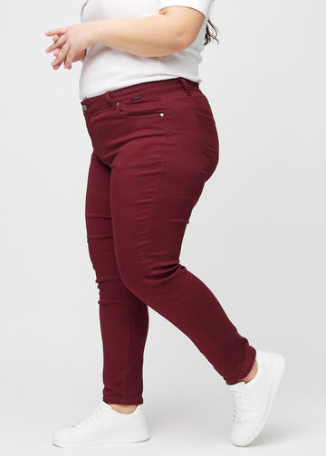 Slim-jeans til kvinner i mørkerød, fargen Santas. Sett fra siden på en plus size-modell.