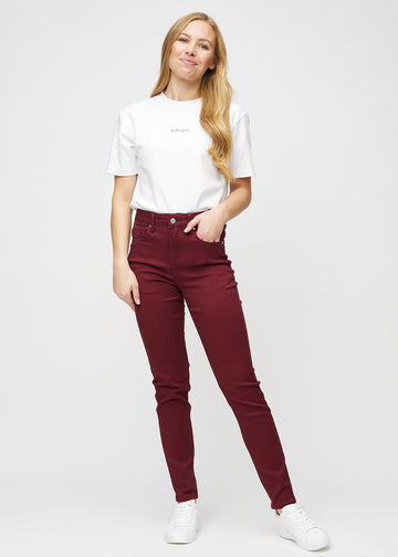 Slim-jeans til kvinner i mørkerød, fargen Santas. Helhetsbilde av en modell med jeansen på.