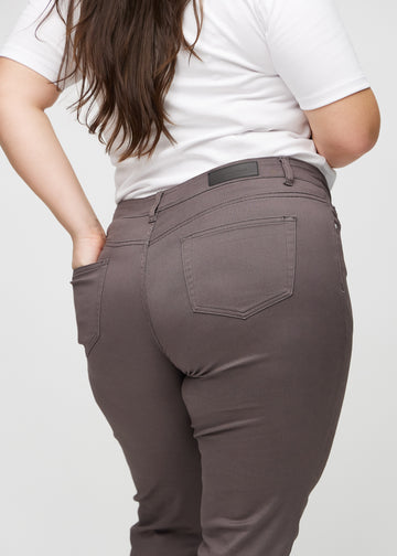 Slim-jeans til kvinner i gråbrun, fargen Thunders. Nærbilde bakfra på en plus size-modell for å vise detaljene.
