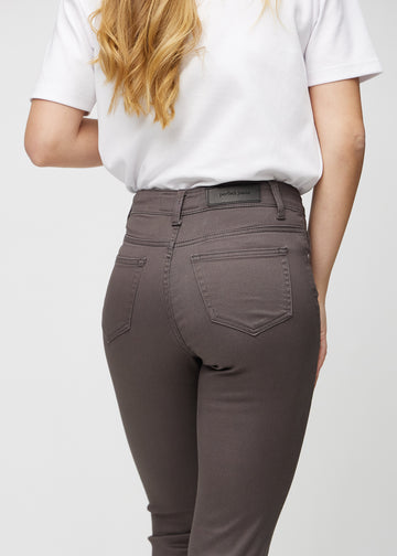 Slim-jeans til kvinner i gråbrun, fargen Thunders. Nærbilde bakfra på en modell for å vise detaljene.