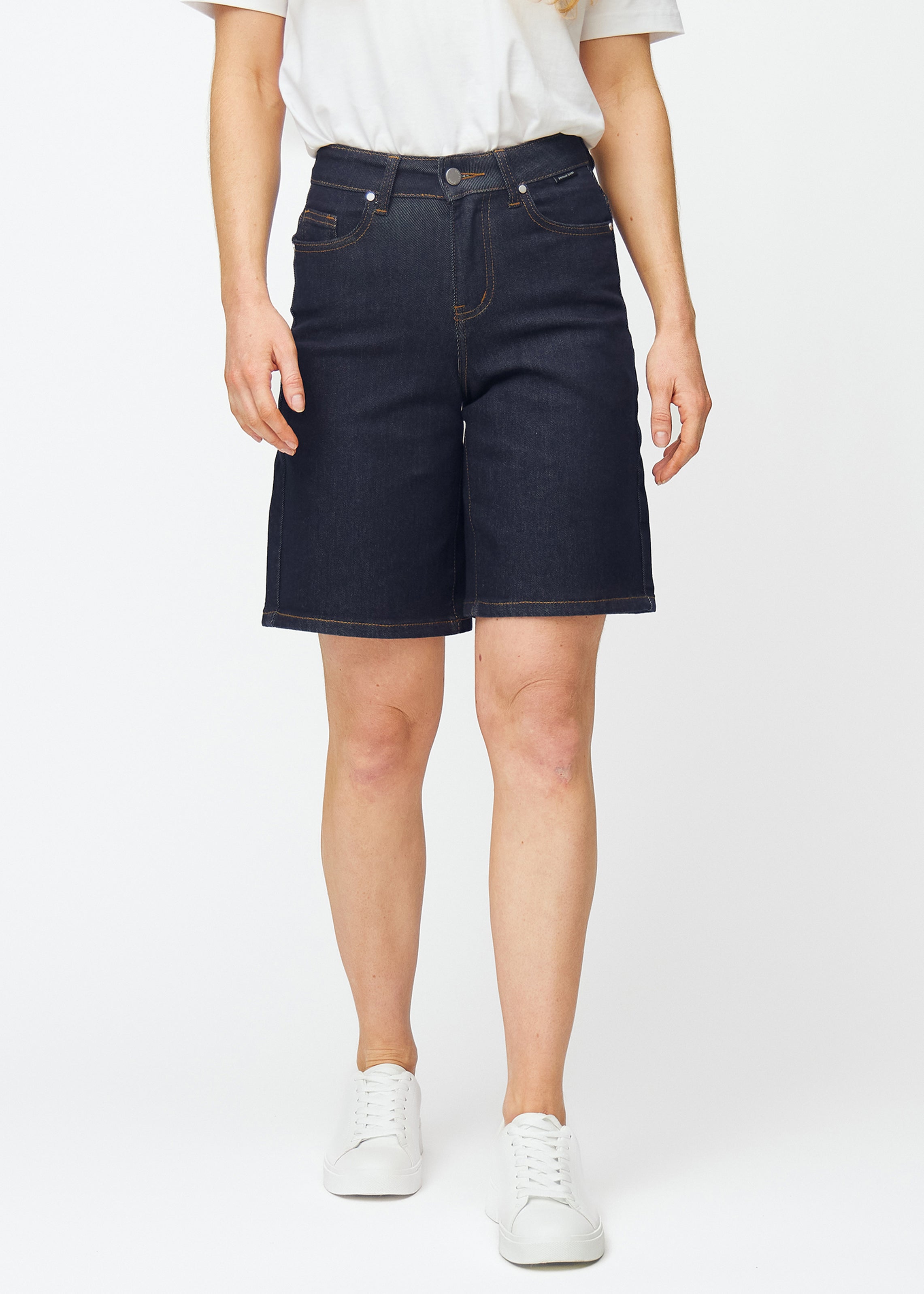 Dyp mørkeblå denimshorts til dame i fargen Midnights med loose passform som sitter ved hoften og faller løst over lårene, sett forfra.