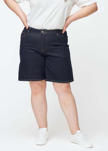 Dyp mørkeblå denimshorts til dame i fargen Midnights med loose passform sett forfra på plus-size modell.