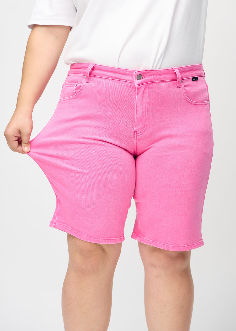 Plus-size-modellen strekker shortsen ved låret for å vise stretch.